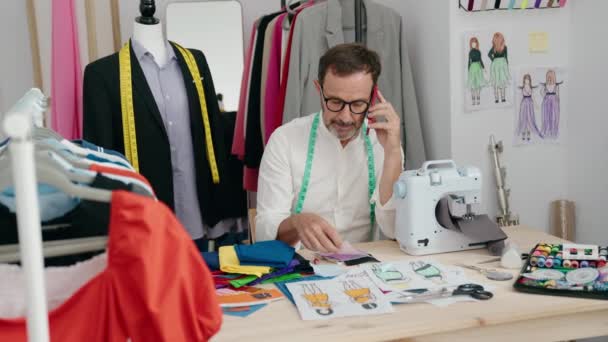 中年男人裁缝在裁缝店用智能手机拿着布说话 — 图库视频影像