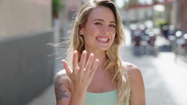 Genç Sarışın Kadın Gülümsüyor Kendinden Emin Sokakta Kol Hareketi Yapıyor — Stok video