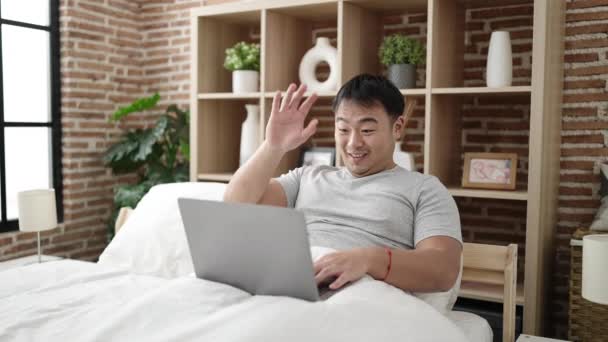 Jonge Chinese Man Met Video Call Zittend Bed Slaapkamer — Stockvideo