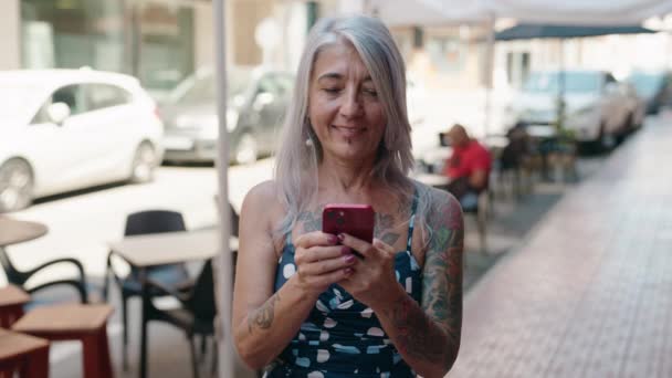 中年灰发女子在街上用带有赢家表情的智能手机 — 图库视频影像