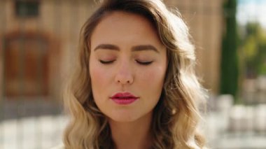 Sokakta kendine güvenen genç sarışın kadın gülümsüyor