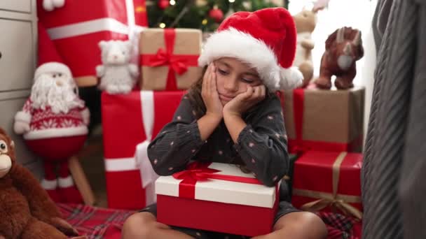 Rozkošná Hispánská Dívka Drží Dárek Sedí Podlaze Vánočního Stromku Smutným — Stock video