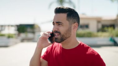 Genç İspanyol adam akıllı telefondan konuşuyor. Sokakta nöbet tutuyor.