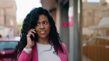 African american woman executive smiling confident talking on the smartphone at street