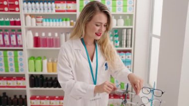 Eczanede konuşan genç ve güzel İspanyol kadın eczacı.