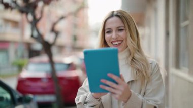 Genç sarışın kadın gülümsüyor. Kendine güveni tam.