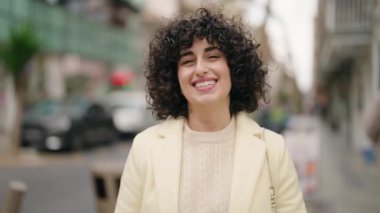 Young woman smiling confident standing with arms crossed gesture at street
