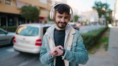 Genç İspanyol adam izliyor, müzik dinliyor ve sokakta dans ediyor.