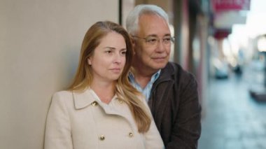 Middle age couple couple smiling confident hugging each other at street