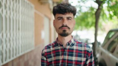 Sokakta kendinden emin gülümseyen İspanyol genç adam.