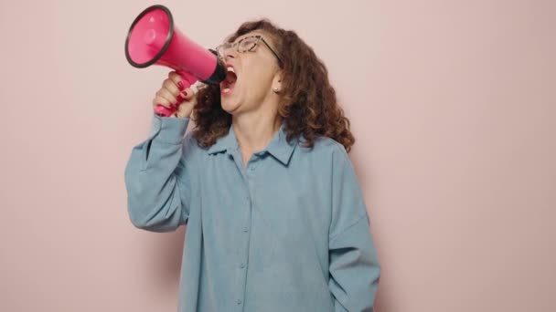 Mujer Mediana Edad Gritando Enojada Usando Megáfono Sobre Fondo Rosa — Vídeos de Stock