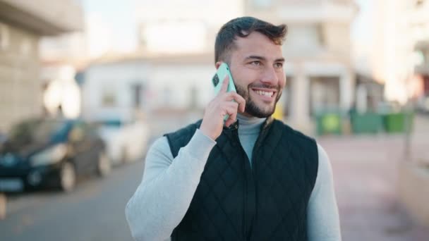 Jonge Spaanse Man Glimlacht Vol Vertrouwen Praten Smartphone Straat — Stockvideo