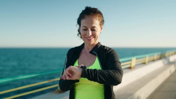穿着运动服的中年妇女面带微笑 自信地看着海滨的秒表 — 图库视频影像