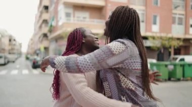 Two african american women smiling confident speaking at street