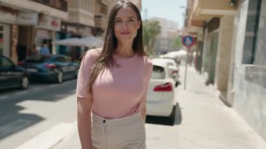 Sokakta kollarını kavuşturmuş genç, güzel İspanyol bir kadın.