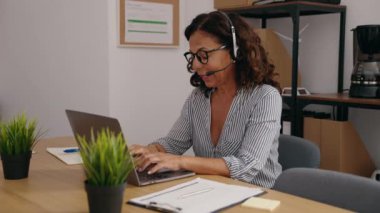 Middle age woman call center agent working at office
