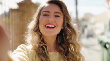 Genç sarışın kadın gülümsüyor. Kendine güveni tam.