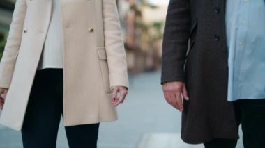 Middle age couple couple walking with hands together at street