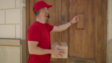 Young hispanic man deliveryman holding package at street