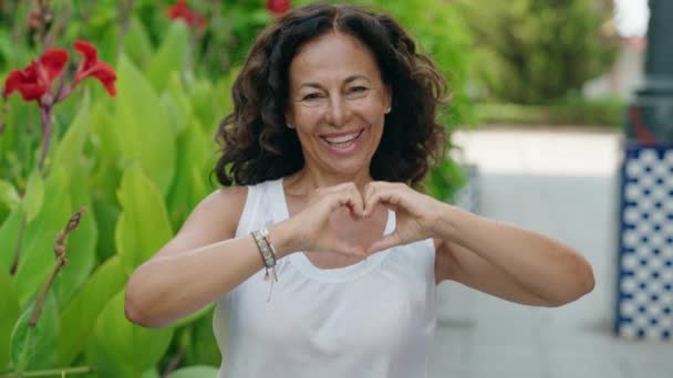 Kobieta Średnim Wieku Uśmiecha Się Pewnie Robiąc Gest Serca Dłońmi — Wideo stockowe
