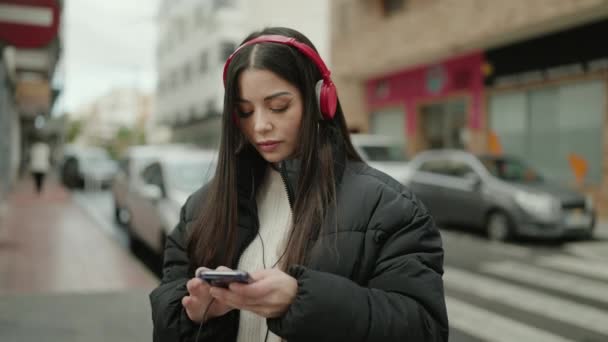 Young Hispanic Woman Listening Music Using Smartphone Street — Stockvideo
