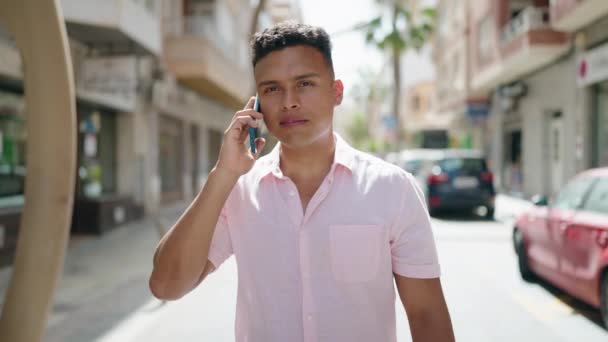 Νέοι Λατίνος Άνθρωπος Χαμογελά Αυτοπεποίθηση Μιλώντας Στο Smartphone Πόδια Στο — Αρχείο Βίντεο