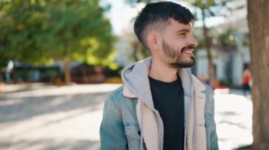 Parkta kendinden emin gülümseyen İspanyol genç adam.