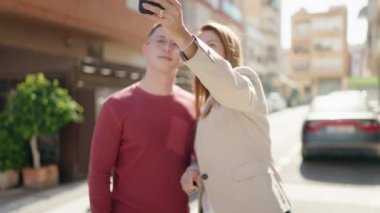 Kadın ve erkek, anne ve oğul gülümsüyor. Kendilerine güveniyorlar. Akıllı telefonlardan selfie çekiyorlar.