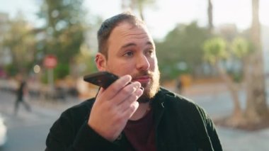 Young plus size man smiling confident talking on the smartphone at park