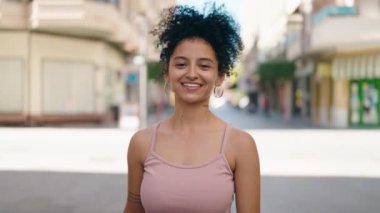 Sokakta kendine güvenen genç İspanyol kadın gülümsüyor