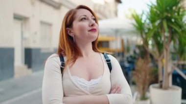 Young redhead woman smiling confident standing with arms crossed gesture at street