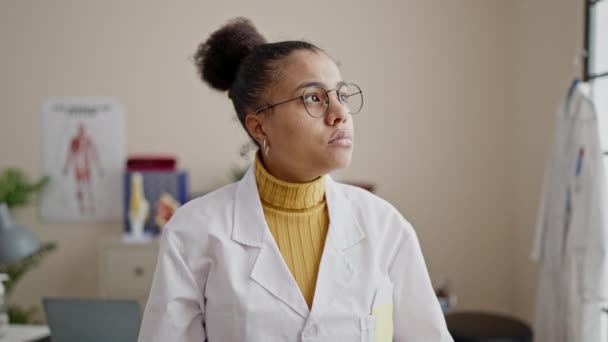 Joven Mujer Afroamericana Doctora Sonriendo Confiada Poniendo Estetoscopio Cuello Clínica — Vídeo de stock