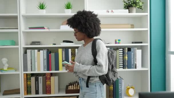 Africano Americano Mulher Estudante Procura Livro Usando Smartphone Universidade Biblioteca — Vídeo de Stock