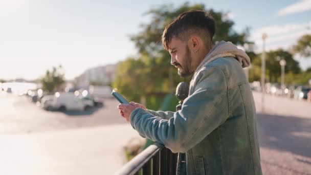 Молодий Іспаномовний Чоловік Посміхається Впевнено Використовуючи Смартфон Вулиці — стокове відео