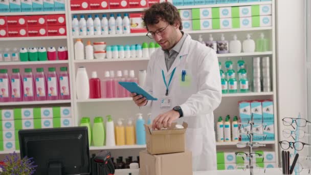Joven Farmacéutico Hispano Usando Touchpad Sosteniendo Botella Pastillas Farmacia — Vídeos de Stock