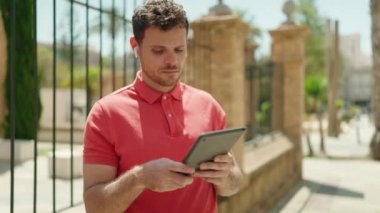 Latin kökenli genç adam Touchpad 'de video izliyor.