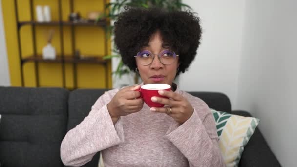 Молодая Американка Африки Пьет Чай Сидя Дома Диване — стоковое видео