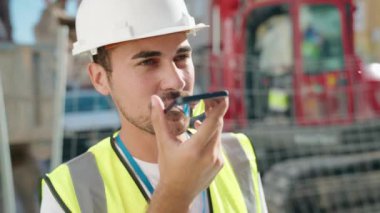 Genç İspanyol mimar caddede akıllı telefondan konuşuyor.