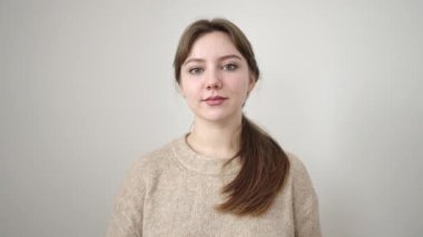 İzole edilmiş beyaz arka planda duran kendine güvenen genç sarışın kadın.