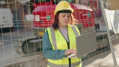 Sokakta dizüstü bilgisayar kullanan genç, güzel, iri yarı bir kadın mimar.