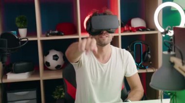 Genç İspanyol asıllı adam video oyunu oynuyor. Müzik stüdyosunda sanal gerçeklik gözlüğü kullanıyor.