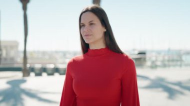 Young woman smiling confident standing at seaside