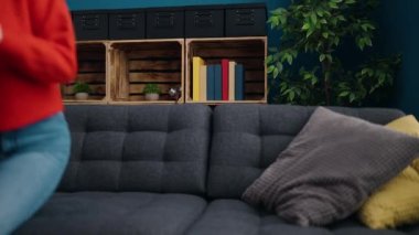 Young blonde woman lying on sofa sleeping at home