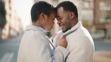 African american couple kissing and hugging each other at street