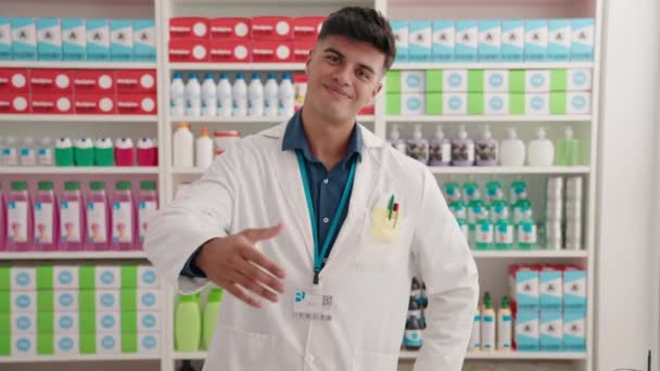 Jovem Homem Hispânico Farmacêutico Sorrindo Mão Apertar Confiante Farmácia — Vídeo de Stock