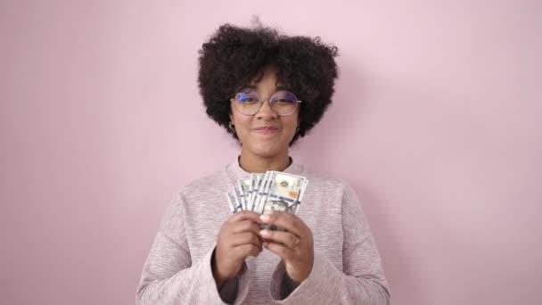 Jonge Afrikaanse Amerikaanse Vrouw Glimlachen Zelfverzekerd Gooien Dollars Geïsoleerde Roze — Stockvideo