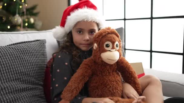 Adorable Hispanic Girl Hugging Monkey Doll Sitting Sofa Christmas Tree — Video
