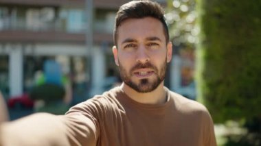 Latin asıllı genç adam gülümsüyor.