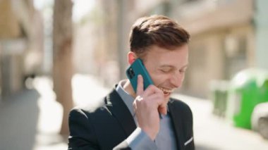 Kafkasyalı genç adam gülümsüyor. Kendine güvenen caddedeki akıllı telefondan konuşuyor.