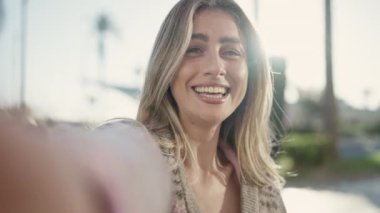 Genç sarışın kadın gülümsüyor. Kendine güveni tam.